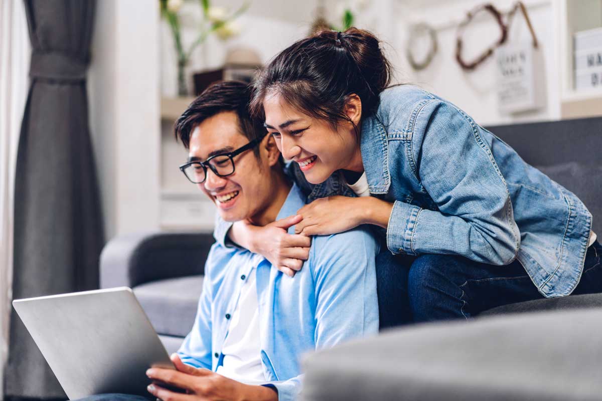 Young couple researching mortgage options on a laptop